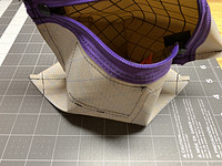 Corners popped out and diagonal lines sewn across popped out corners to create an angled bottom of the bag. It would be flat if these stitch lines were perpendicular.